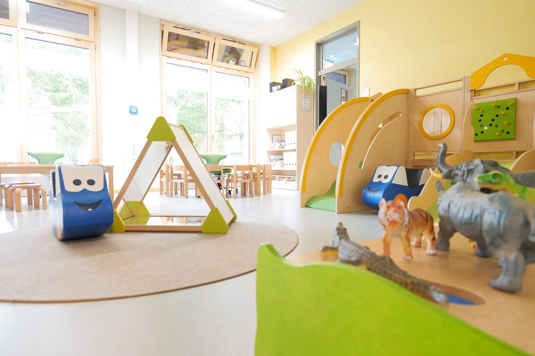 Spielbereich im Gruppenraum der Kita Ohrnsweg mit bunten Spielmodulen, Tierfiguren und kindgerechten Möbeln, die das kreative Spielen fördern.