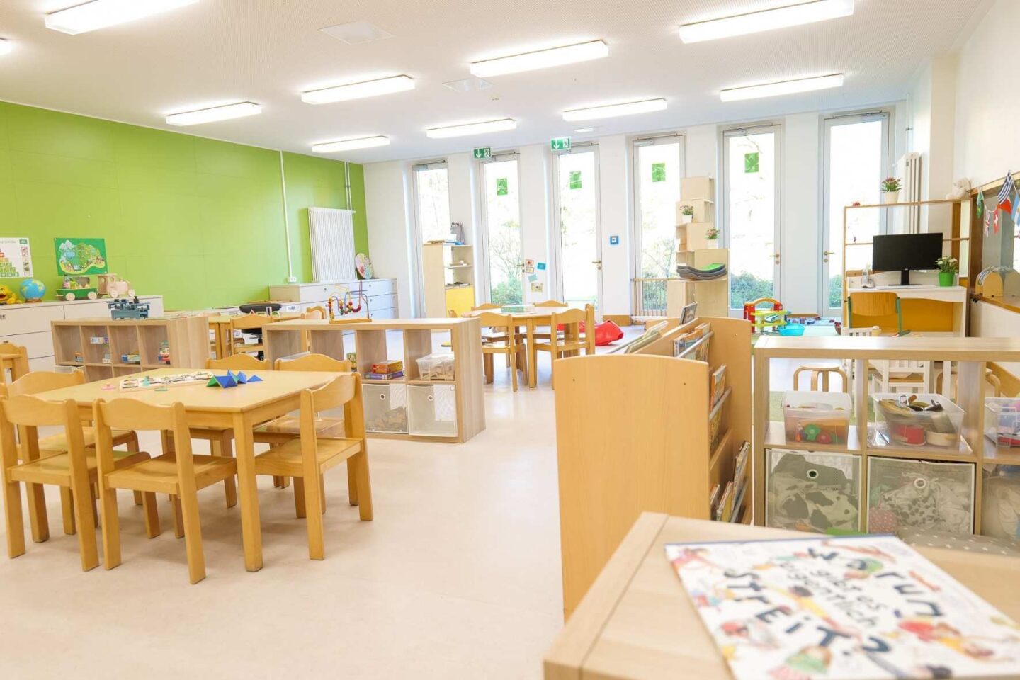 Moderner und heller Gruppenraum der Kita Barlsheide mit pädagogischen Spielmaterialien und Lernstationen.