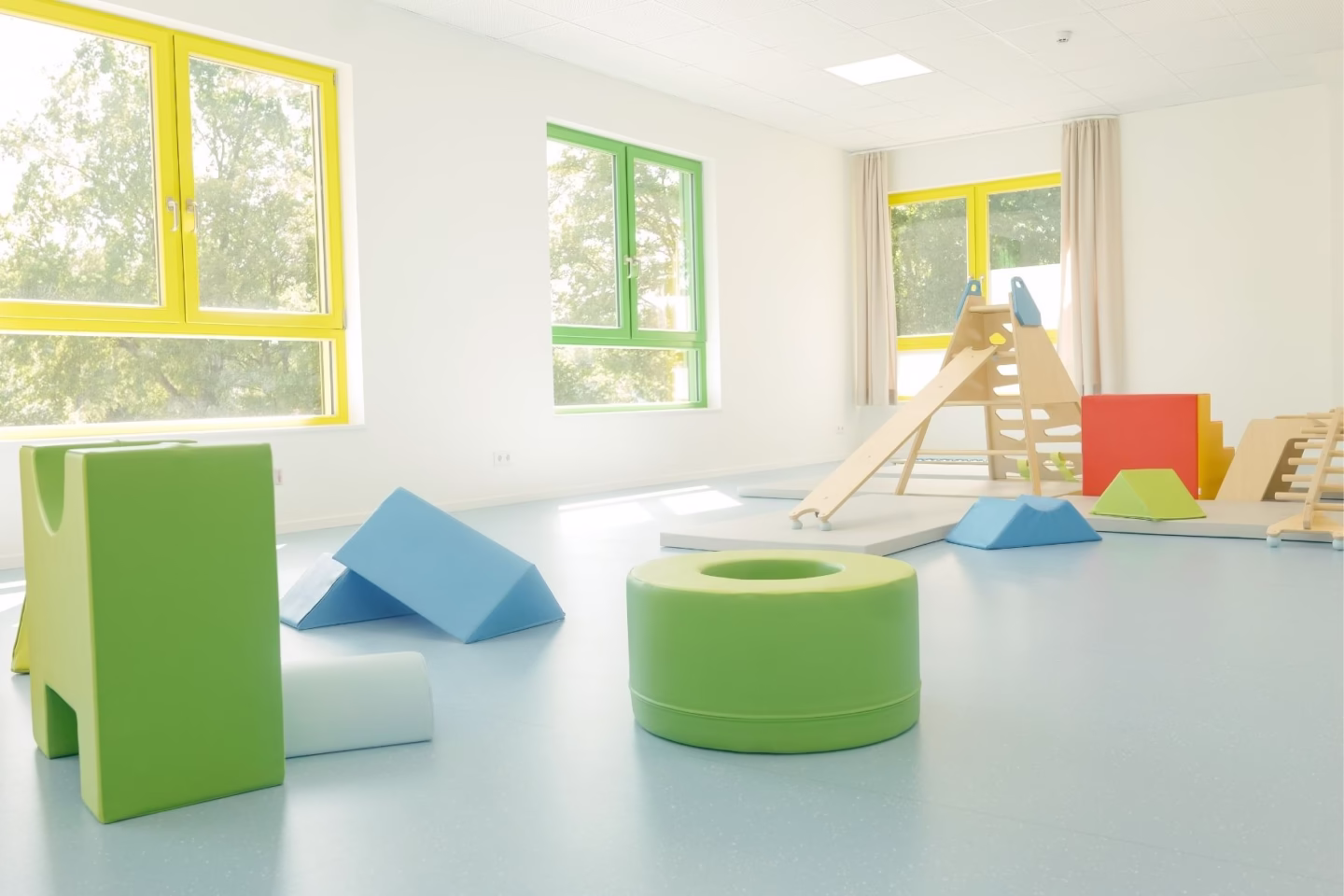 Großer Bewegungsraum in der Kita mit Turnmatten und Spielgeräten