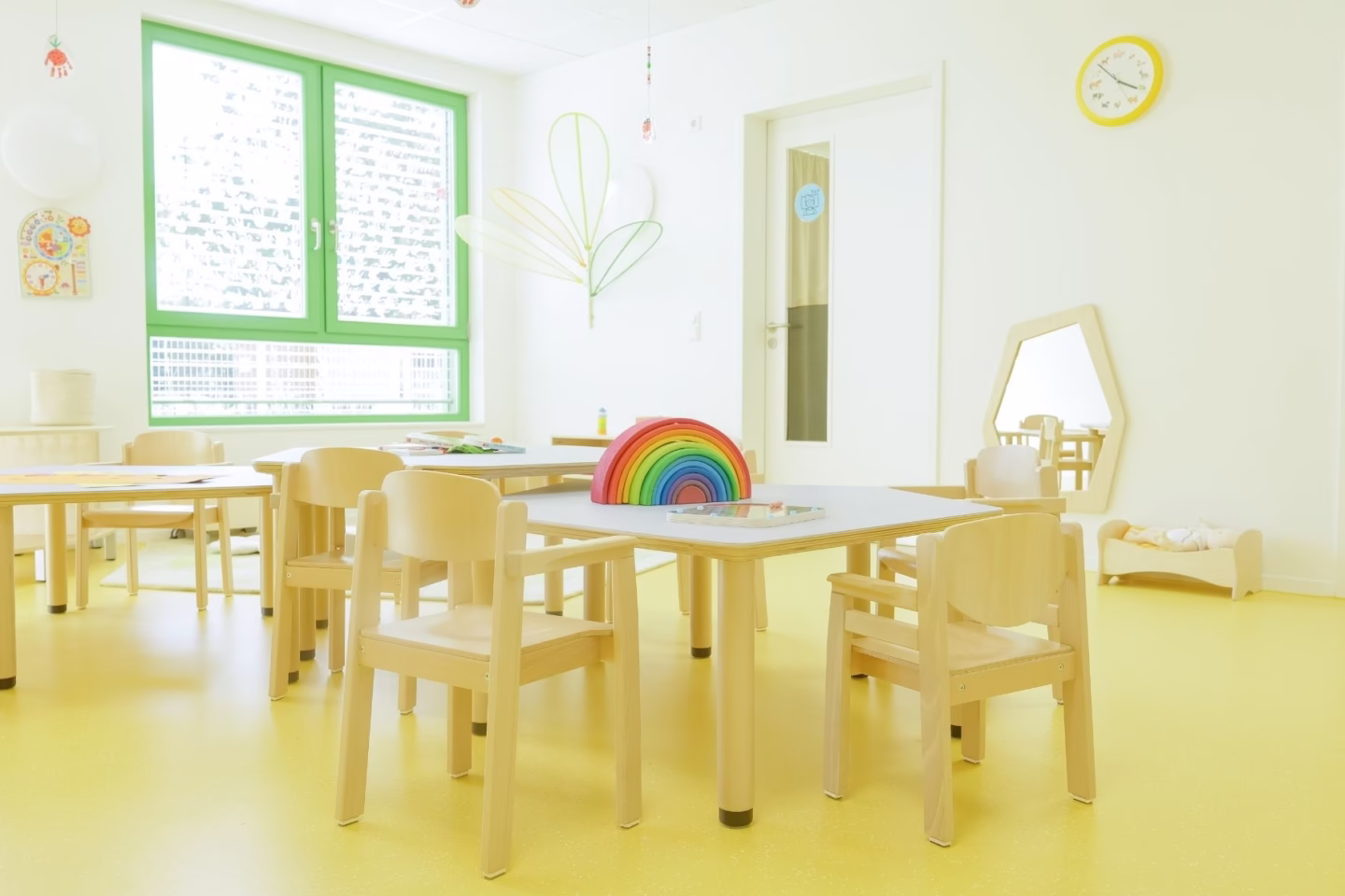 Freundlicher Kindergartenraum mit Tischgruppe und Stühlen für kreative Aktivitäten
